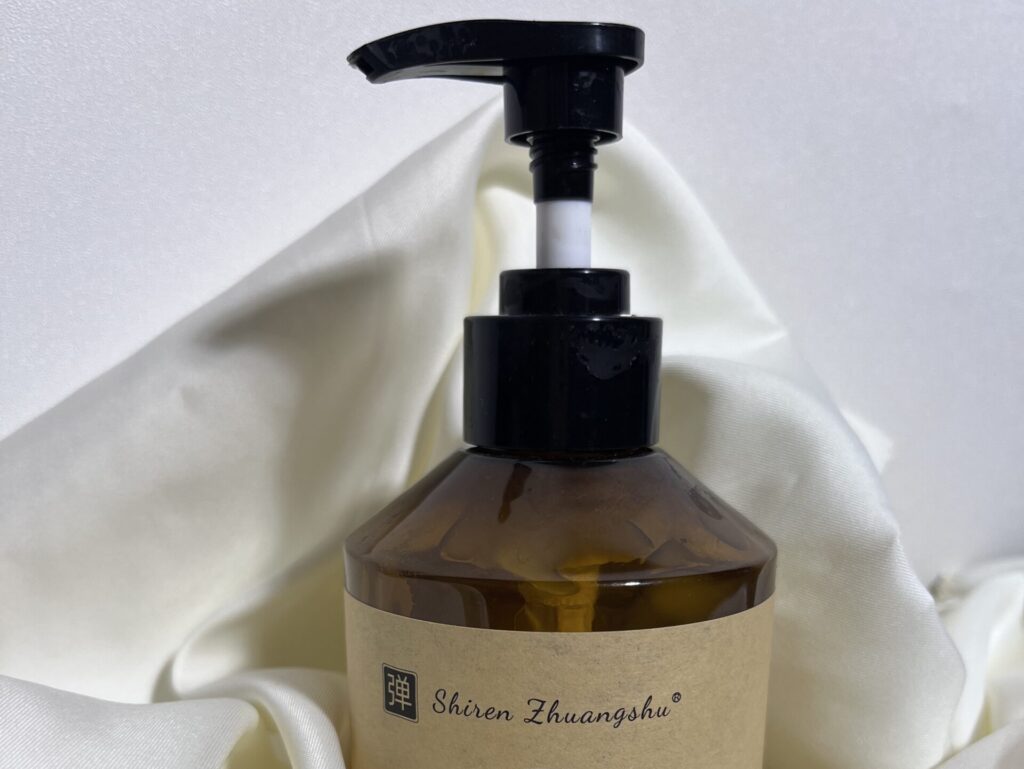 Moroccan Hydrating Elastin Curl Cream bottle on a clean background with white fabric