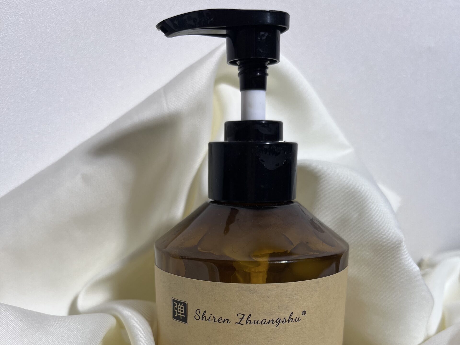 Moroccan Hydrating Elastin Curl Cream bottle on a clean background with white fabric