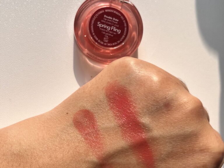 Hand swatch of Wander Beauty Double Date Lip and Cheek Spring Fling under natural sunlight, single swipe on left and multiple swipes on right