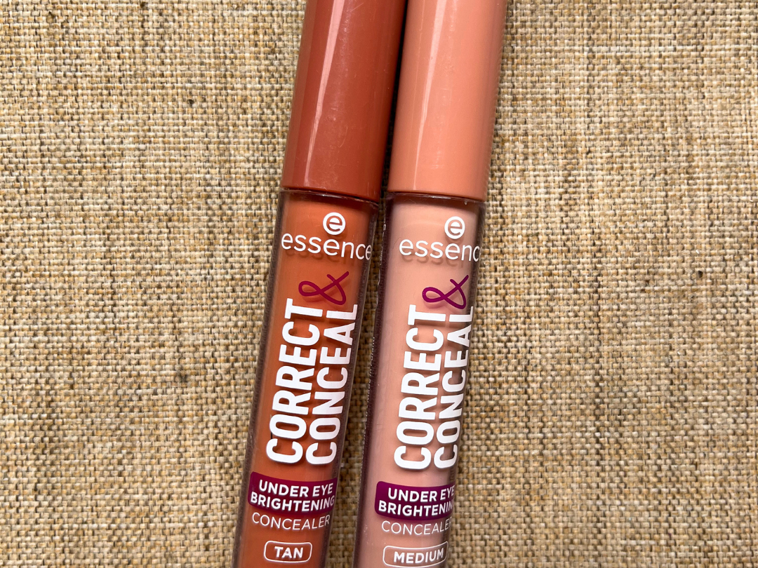 Two Essence Correct & Conceal Under Eye Brightening concealers on a beige textured background