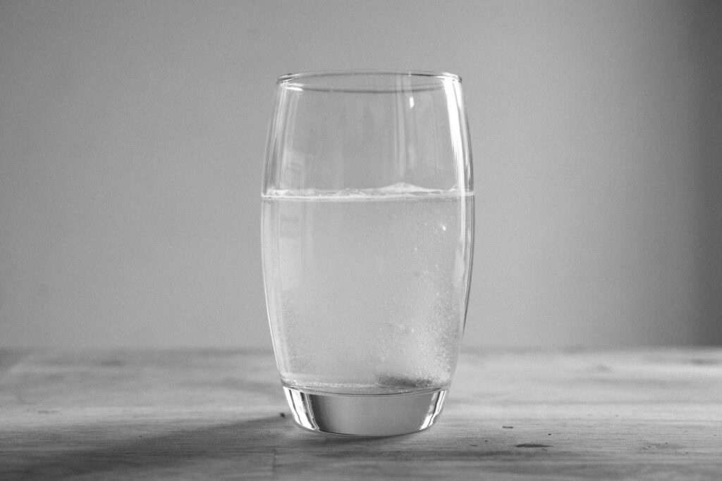 Glass of water on a table representing hydration for skin health