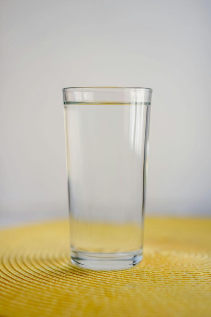 Full glass of water representing consistent hydration for skin health