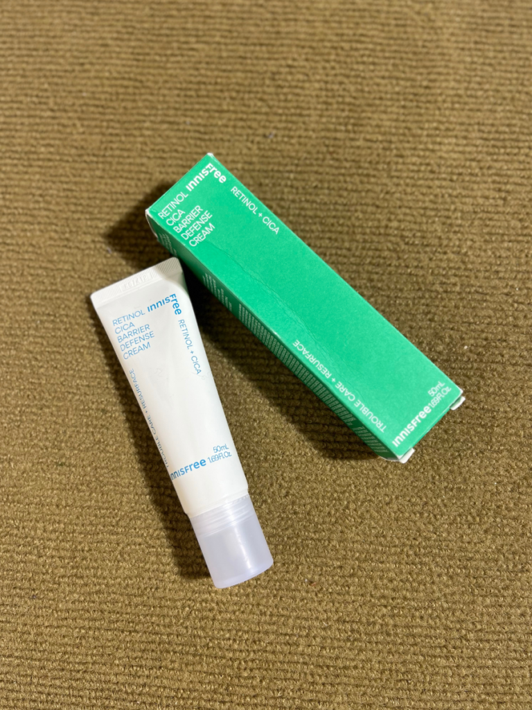 Innisfree Retinol Cica Barrier Cream and its green outer box displayed on a beige textured surface.