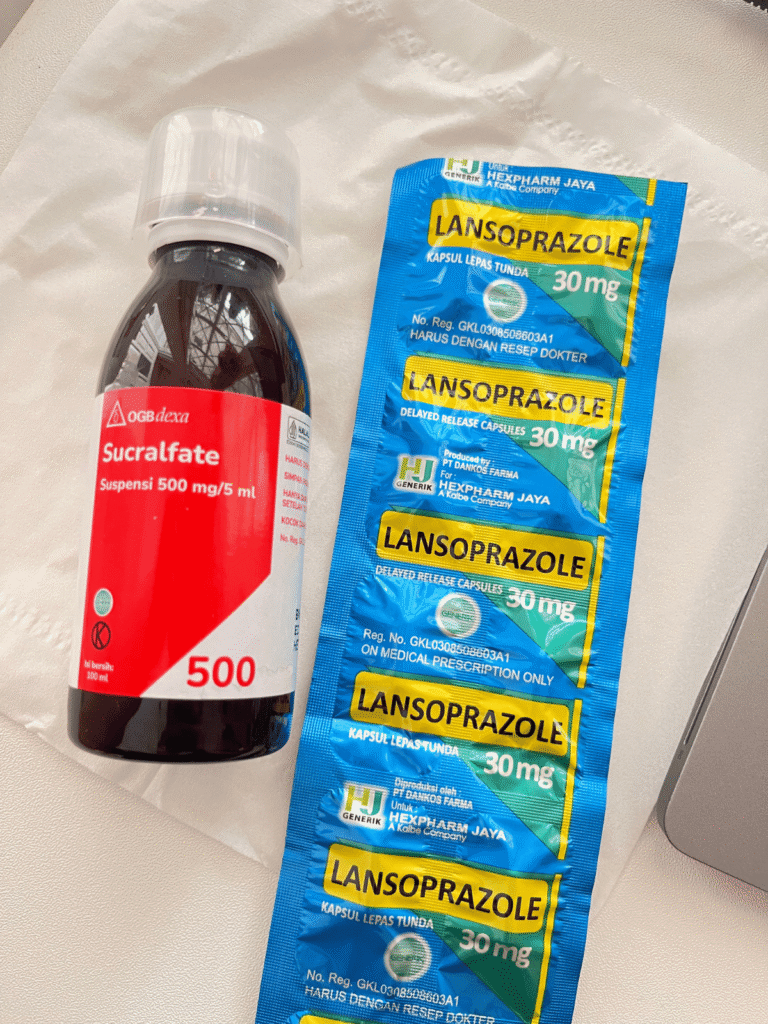A blister pack of Lansoprazole 30mg capsules and a bottle of Sucralfate suspension syrup